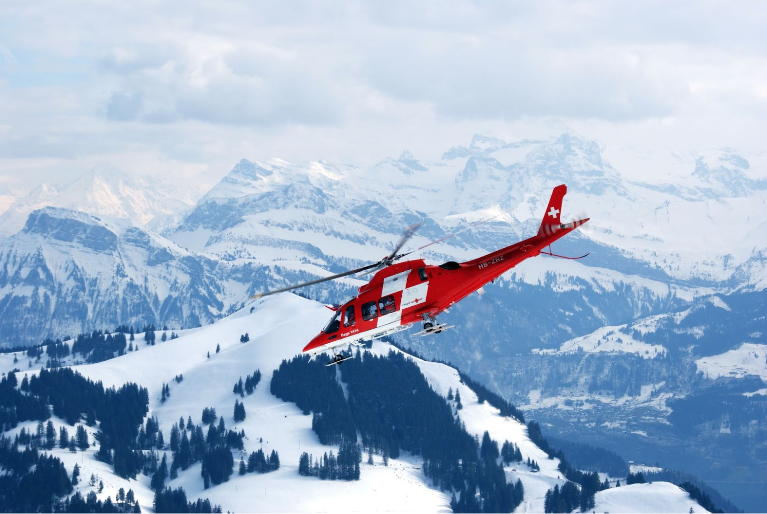 Rescue helicopter flies above mountains